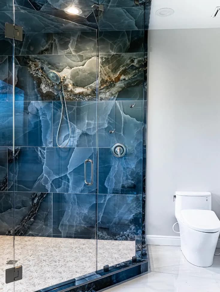 Blue onyx-look shower with frameless glass next to toilet