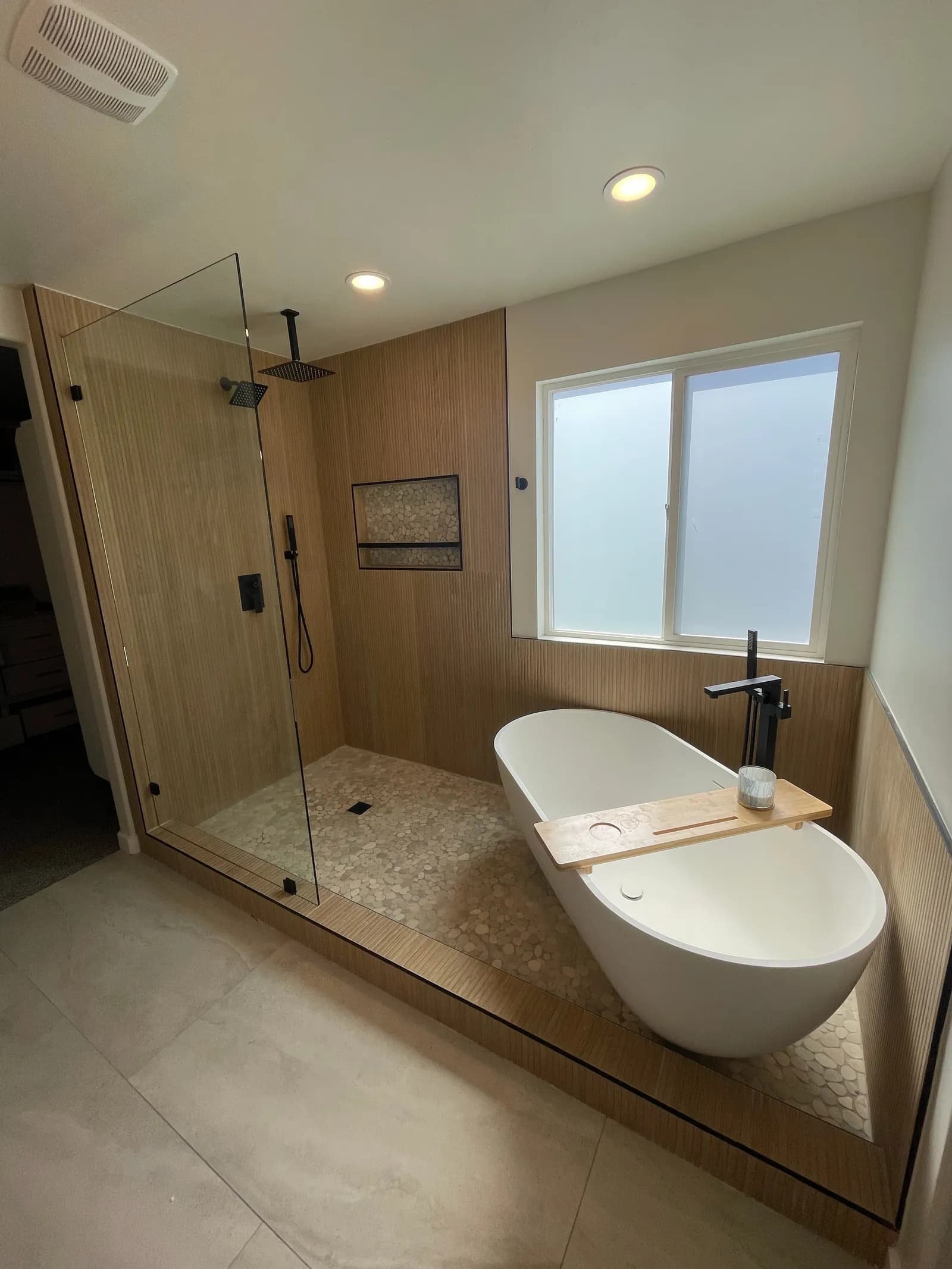 Remodeled master bath with freestanding tub and walk-in glass shower