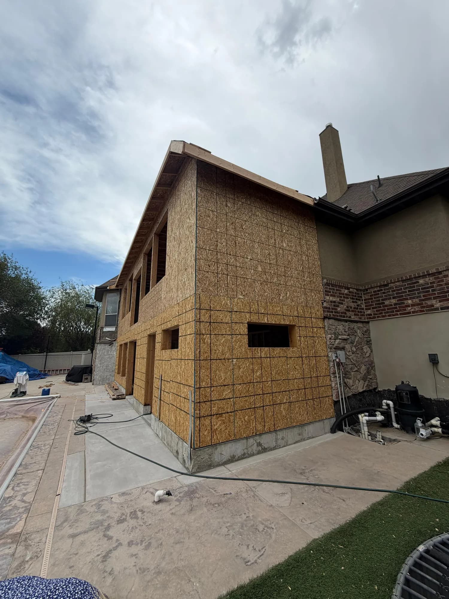 Same addition, OSB sheathing tied into existing brick/stucco house