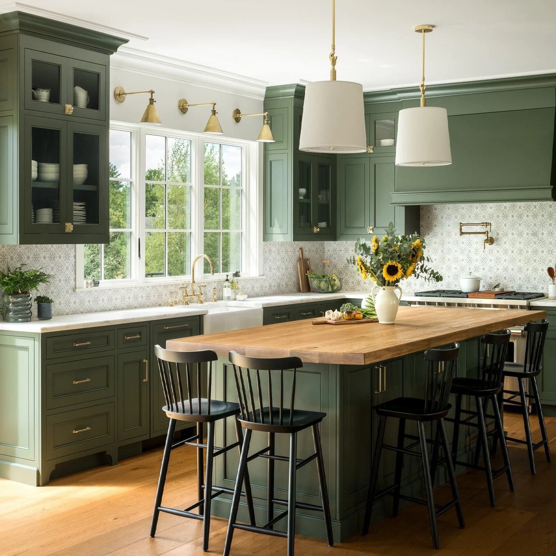 Oak kitchen with black pulls, quartz counters, and stacked stone tile behind the range