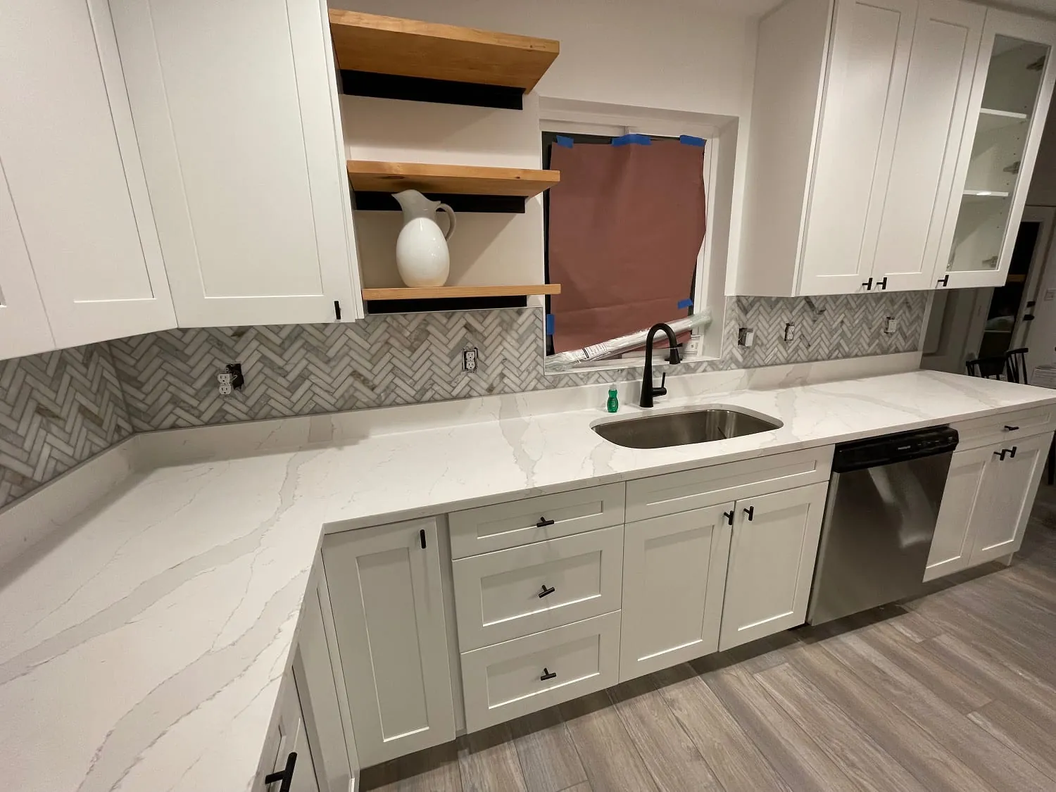Same white shaker kitchen, sink wall with undermount sink and floating wood shelves