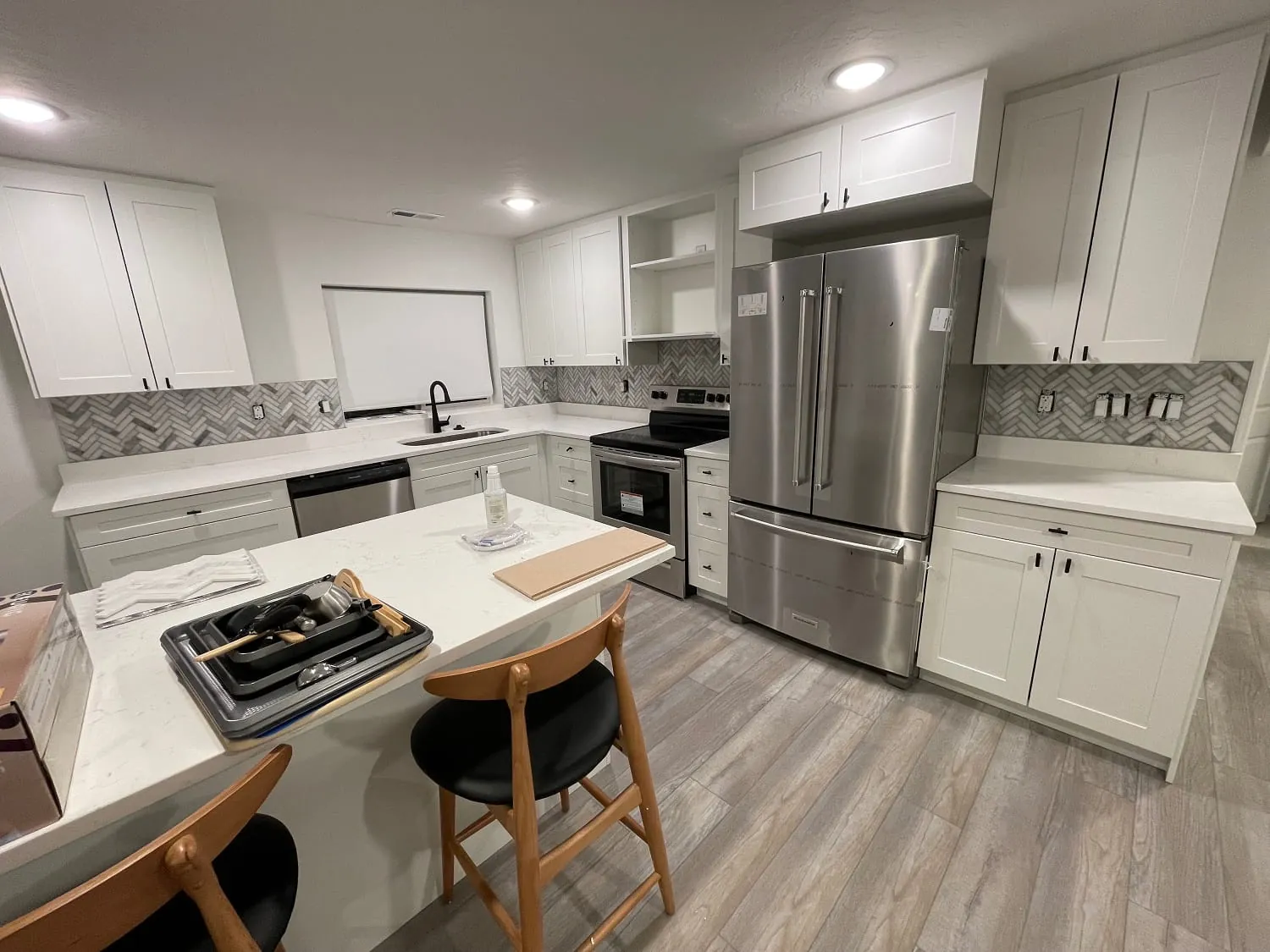 Same kitchen, island with stools and French-door stainless fridge