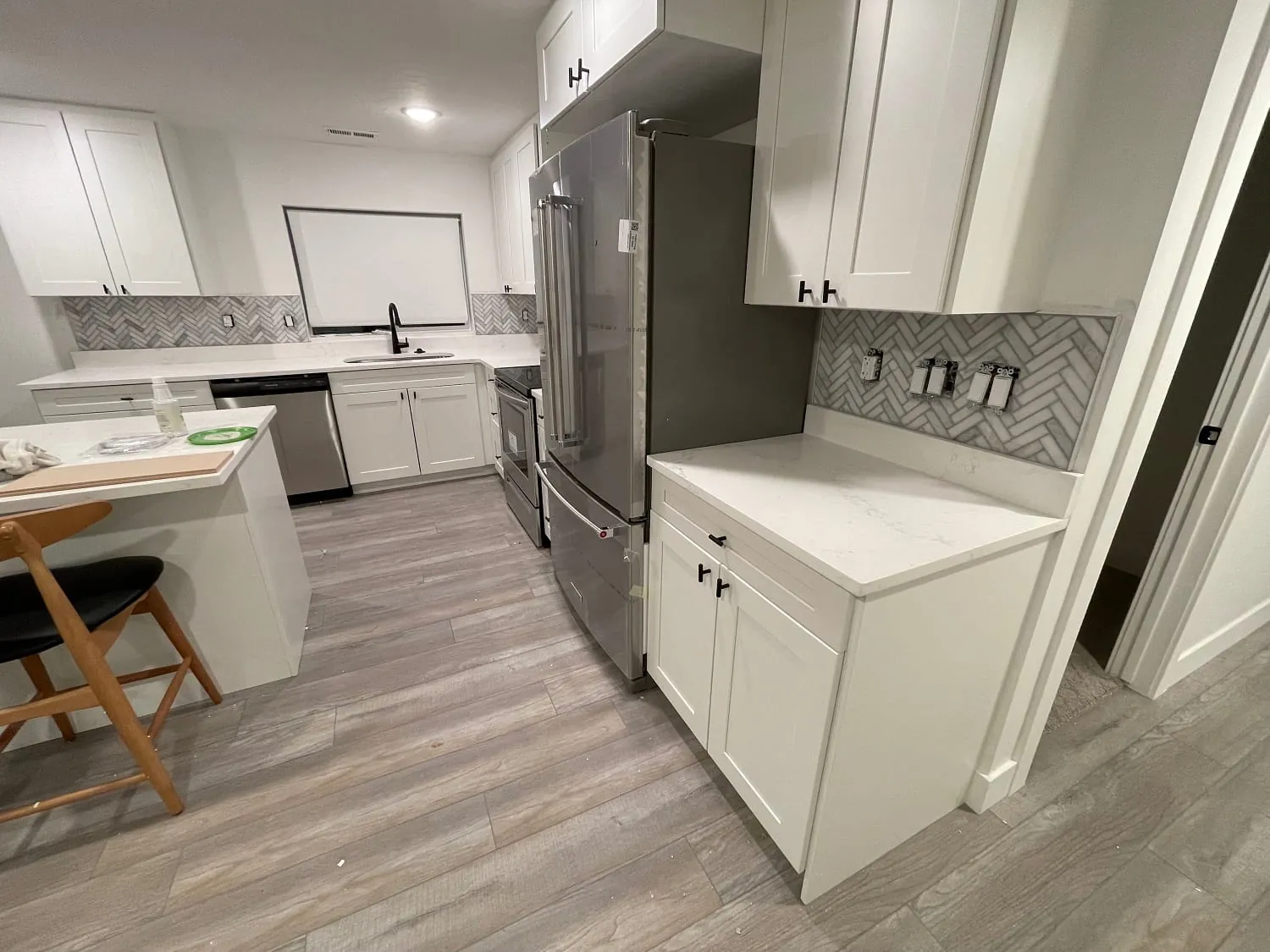 Same kitchen, wide view with island and fridge wall
